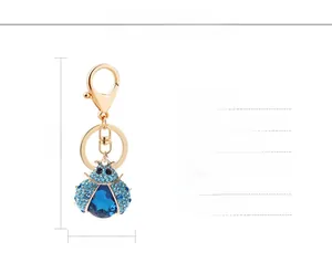 Detailed view of rhinestone ladybug keychain measuring 10cm by 3.5cm with blue gems