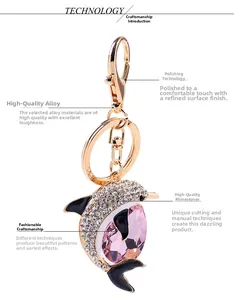 Macro detail of golden dolphin keychain with pink crystal and inlaid white rhinestones