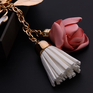 Elegant floral keychain with pink satin rose, white tassel and gold metal hardware for bags