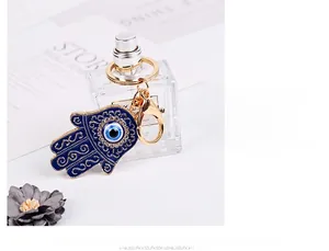 Dettaglio del portachiavi Mano di Fatima con malocchio blu e strass bianchi lucidi