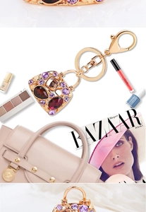 Detailed close-up of a luxury handbag keychain with purple and red crystals on a gold base