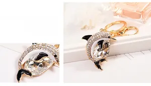 Detail of a golden alloy dolphin keychain featuring inlaid rhinestones and teardrop crystal