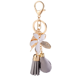 Elegant floral keychain with pearl flower, diamond leaf, and grey leather tassel pendant