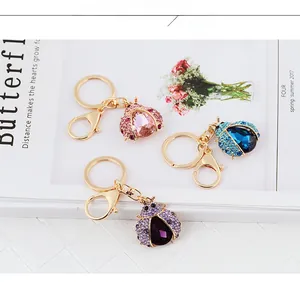 Detailed view of ladybug keychains with colorful rhinestones in pink, blue, and purple