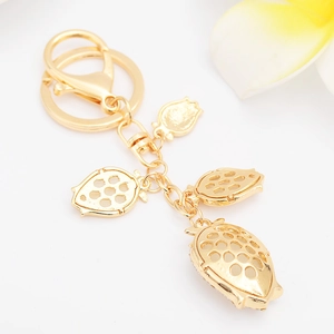 Golden strawberry keychain with sparkling crystals and elegant flower accent decor