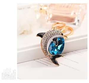 Detail of dolphin keychain with blue teardrop gemstone and sparkling white rhinestones