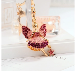 Detailed close-up of a golden angel keychain featuring pink and purple rhinestones