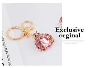 Detailed close-up of pink crystal ladybug keychain with gold base and sparkling rhinestones