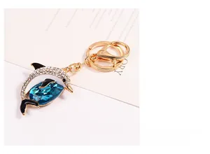 Close-up of golden dolphin keychain featuring blue crystal and white rhinestones