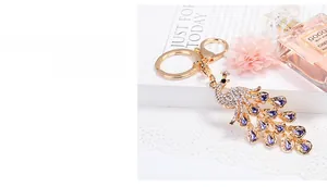 Detail of crystal peacock keychain with sparkling white and purple rhinestones on gold alloy