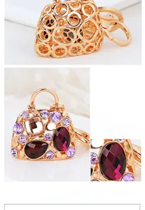 Detail of luxury handbag keychain with purple rhinestones and hollow-out gold plating