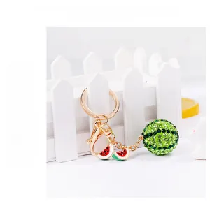 Detail of watermelon keychain featuring green rhinestones and mini enamel fruit charms