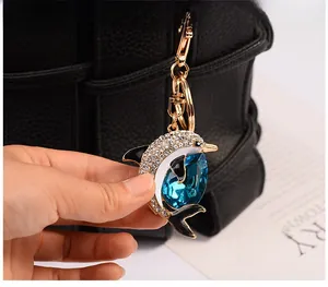 Close-up of golden dolphin keychain featuring dark blue crystal and white zircon inlay