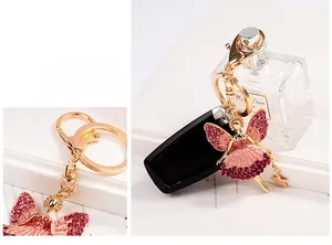 Detailed close-up of a golden angel keychain with pink rhinestones and a star charm