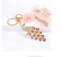 Close-up of golden peacock keychain featuring pink rhinestones and intricate metalwork