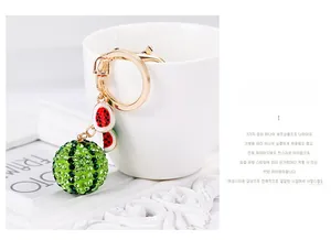 Detailed view of rhinestone watermelon keychain with green crystal ball and red enamel charms