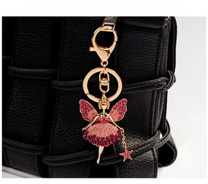 Detailed fairy angel keychain with pink rhinestones on a textured black leather bag