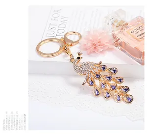 Detail of a sparkling crystal peacock keychain featuring purple gemstones and gold alloy