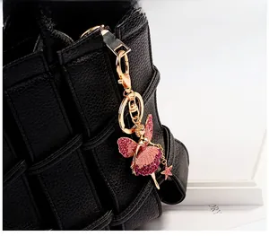 Detail view of angel bag charm with pink rhinestones and gold lobster clasp