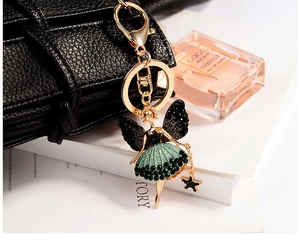 Detail view of angel ballet girl charm with green polka dot dress on a black leather bag