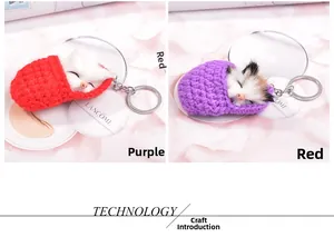 Detail of red and purple knitted cat sleeping bag plush keychain with metal keyring