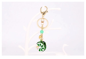 Close-up of green enamel lemon keychain with white crystals and gold plating lobster clasp