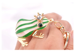 Vue détaillée du porte-clés grenouille prince dorée avec émail vert et strass brillants