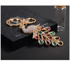 Close-up of crystal peacock keychain with colorful rhinestones on a black gift box