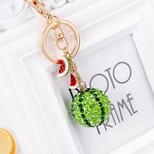 Exquisite rhinestone watermelon keychain with golden accents on an elegant photo frame