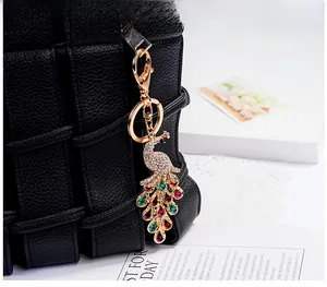 Detail of crystal peacock keychain with colorful gemstones on a black bag
