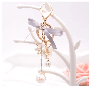 Detail of lavender bow keychain with pearl star and crystal on white display branch
