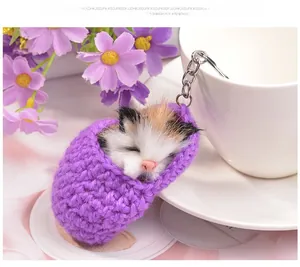 Detailed view of handmade crochet purple pouch with a fluffy tricolor toy cat keychain