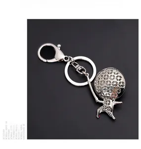 Close-up of polished silver alloy fencer charm keychain with lobster clasp on black background