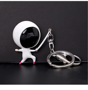 Detail shot of a white creative fencing figure keychain with a polished silver ring