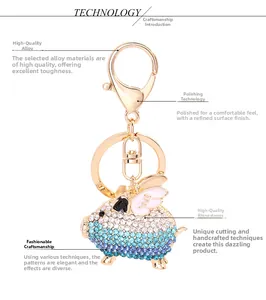 Detail of flying pig keychain featuring gradient rhinestones and pink enamel wings