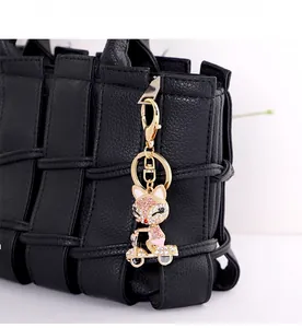 Dettaglio portachiavi a forma di volpe con strass rosa su borsa nera e oro