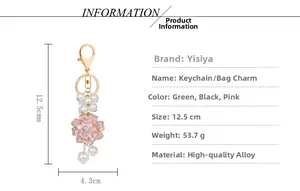 Détail du porte-clés fleur en émail rose avec perles blanches et fermoir doré
