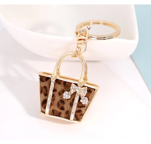 Close-up of leopard print handbag keychain with gold bow and sparkling crystals