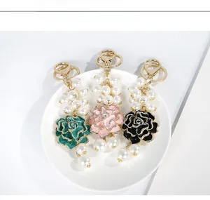 Vue détaillée des breloques camélia en perles verte, rose et noire avec émail et strass