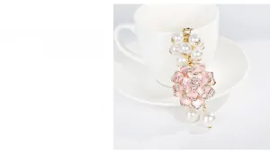 Gros plan détaillé d'un porte-clés camélia en émail rose avec perles et cristaux brillants