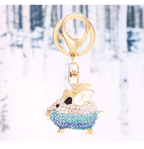 Detailed view of flying pig keychain with gradient blue crystals and gold plating
