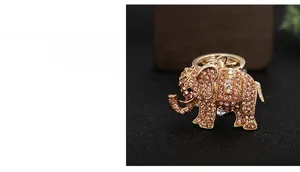 Detailed macro view of an elephant keychain featuring pink crystals and golden alloy
