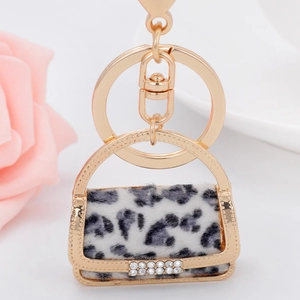 Close-up of leopard print handbag keychain with gold plating and sparkling rhinestones