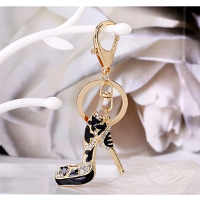 Macro detail of gold alloy high heel keychain with black enamel and crystals