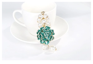 Détail de la rose en émail vert canard avec strass blancs et perles sur une tasse