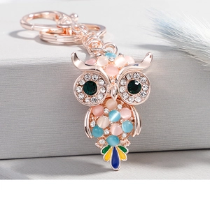 Dettaglio del portachiavi a civetta oro rosa con pietre di opale e strass scintillanti