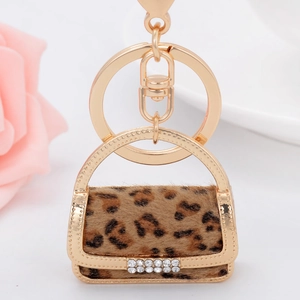 Close-up of leopard print mini bag keychain with gold frame and sparkling rhinestones