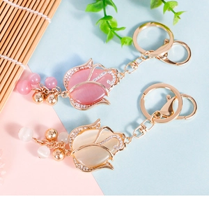 Macro detail of tulip keychain with opal-like resin, gold metal frame and sparkling crystals