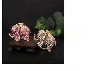 Detail of crystal elephant keychains in pink and white stones on wooden stand