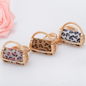 Detailed view of leopard print mini handbag keychains with rhinestones and gold metal frame